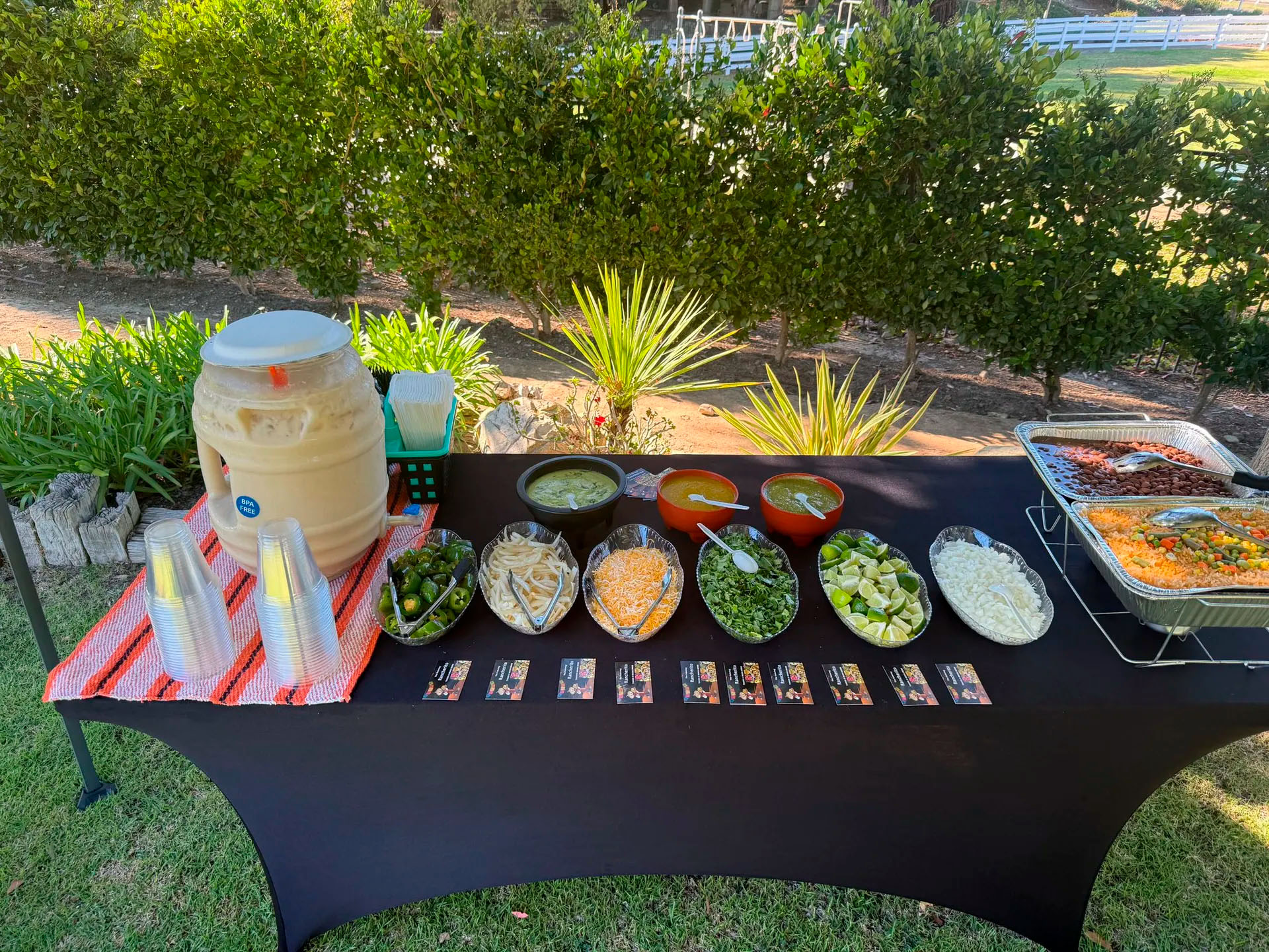 Home Tacolab LA Mexican catering buffet setup in Los Angeles. Fresh ingredients, salsas, toppings, horchata drink and rice for taco bar at events.